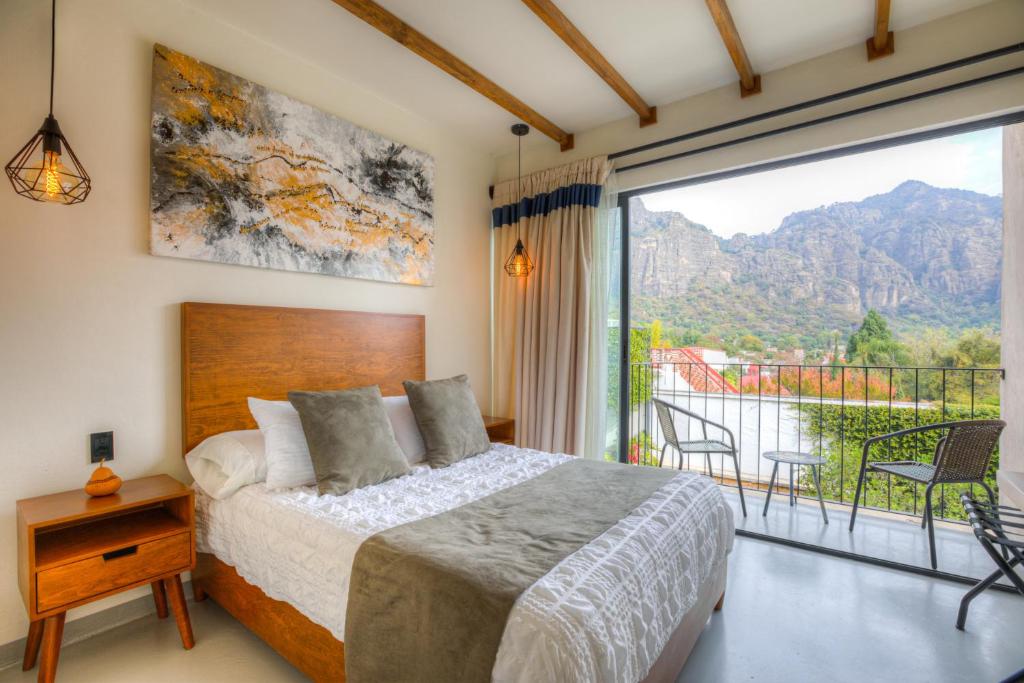 una camera con un letto e una grande finestra di Casa Ehua Hotel Galería a Tepoztlán