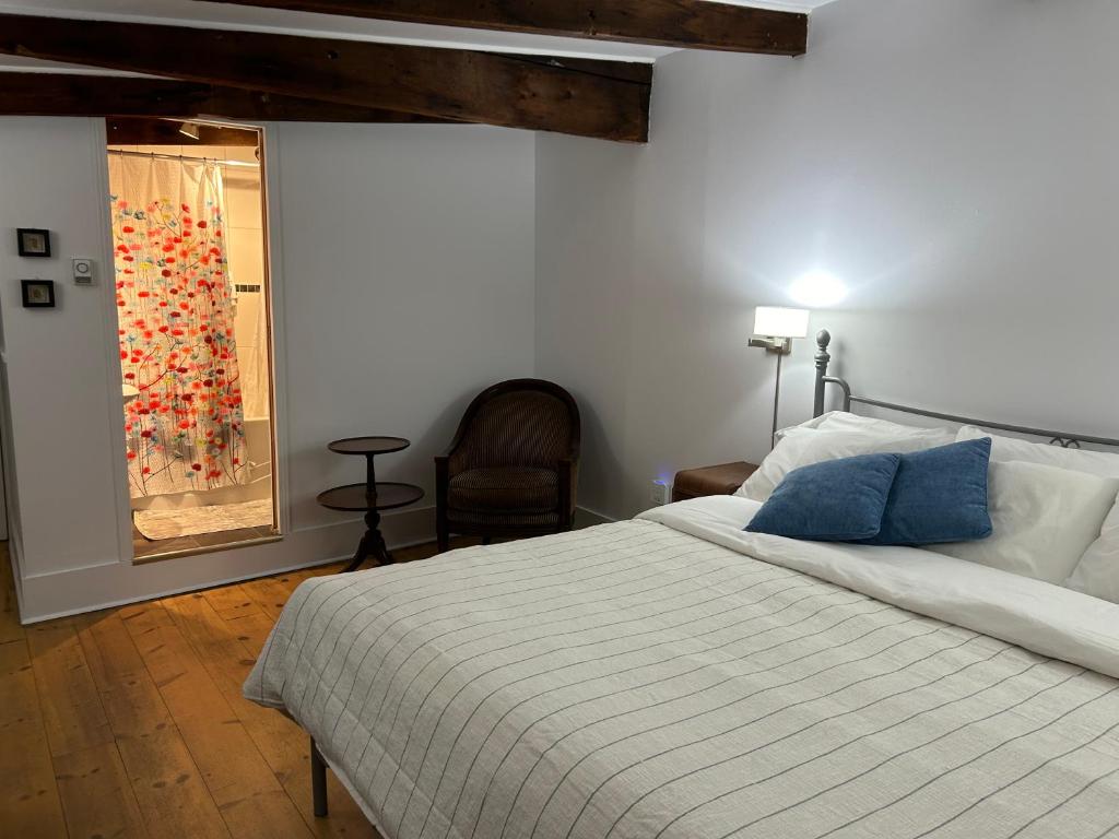 a bedroom with a bed and a chair and a window at À l'Adresse du Centre-Ville in Montréal