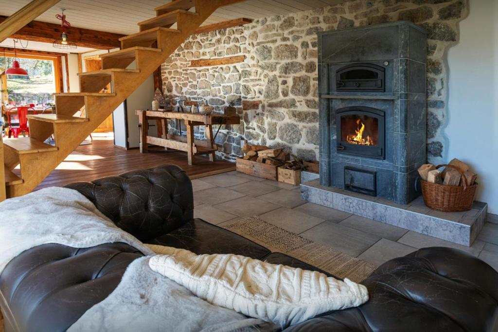 a living room with a couch and a fireplace at La Ferme des Artistes - OVO Network in Mieussy