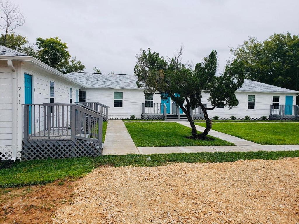 a white house with a tree in the yard at The Place To Stay in Alvin