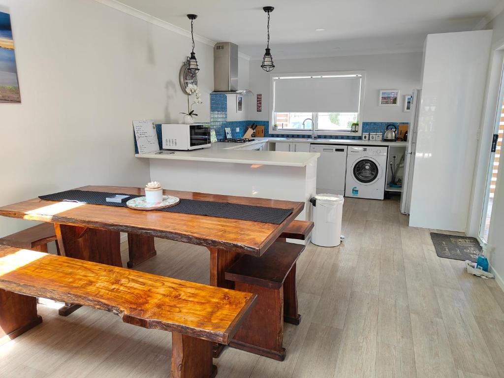 - une cuisine avec une table et des bancs dans l'établissement Kerikeri Sunny Modern 2 Bedroom Apartment, à Kerikeri