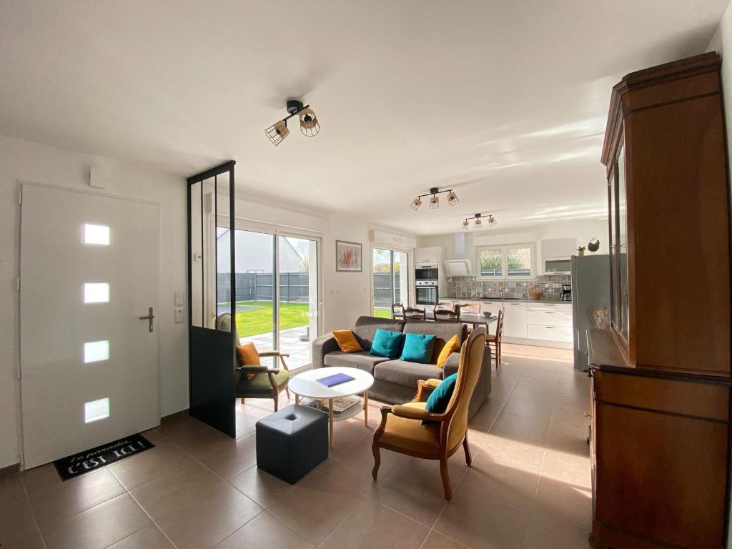 a living room with a couch and a table at Pretty holiday home in Cotentin in Gouville-sur-Mer