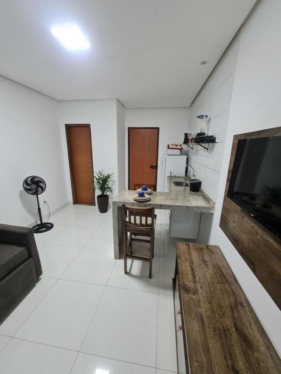 Bahia Trip Flats في لينكويس: مطبخ وغرفة معيشة مع تلفزيون وأريكة