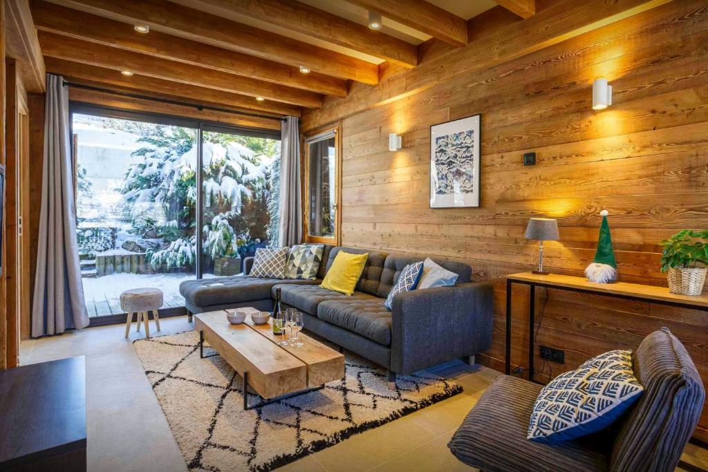 un salon avec un canapé et une table dans l'établissement Chalet Kouzya - OVO Network, aux Gets