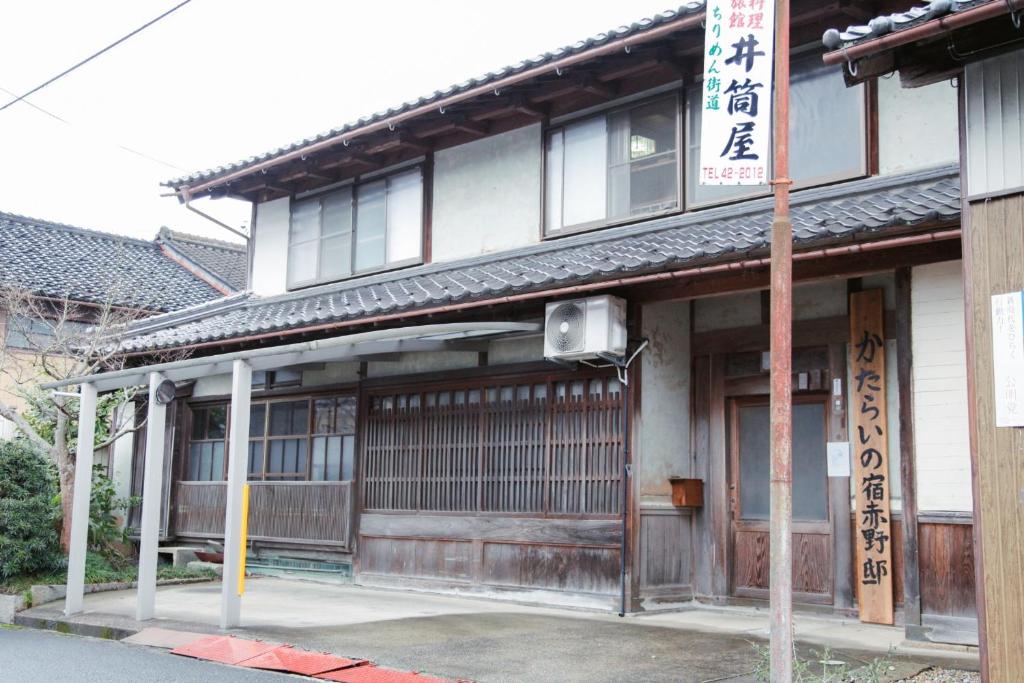 KayaにあるAkano House, an inn of katarai - Vacation STAY 10702の看板が目の前にあるアジア風の建物