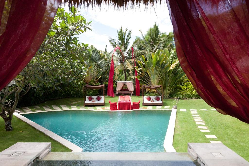 una piscina con 2 sillas y una mesa en un patio en Villa Mathis, en Canggu
