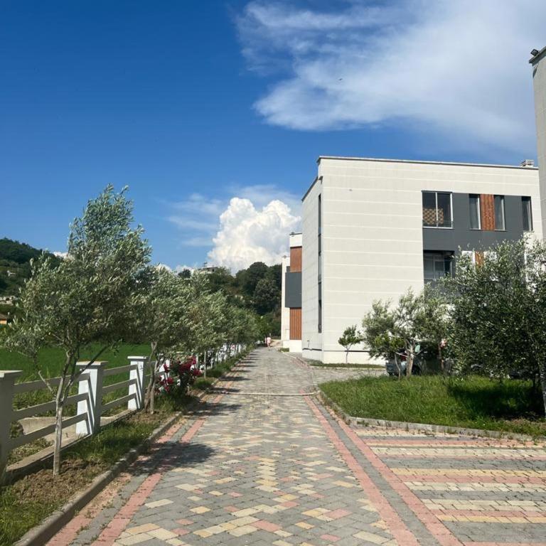 a cobblestone road next to a white building at Real Resort Albania in Fushë-Draç
