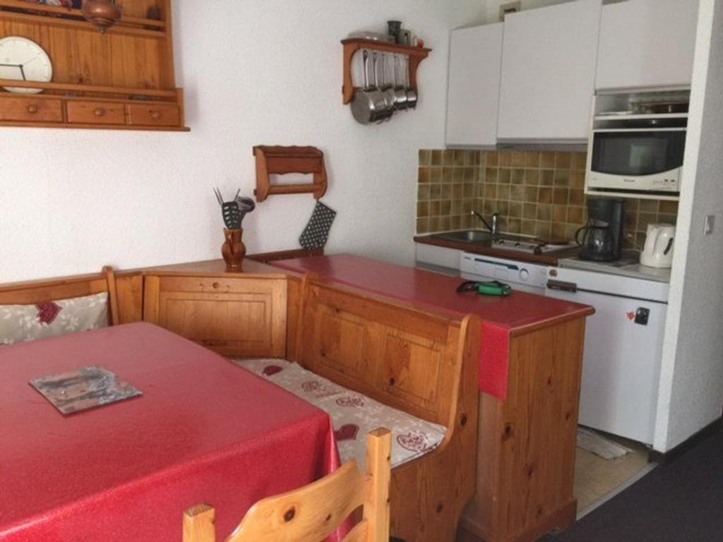 uma cozinha com uma mesa e uma bancada vermelha em Studio Les Orres, 1 pièce, 6 personnes - FR-1-322-545 em Les Orres