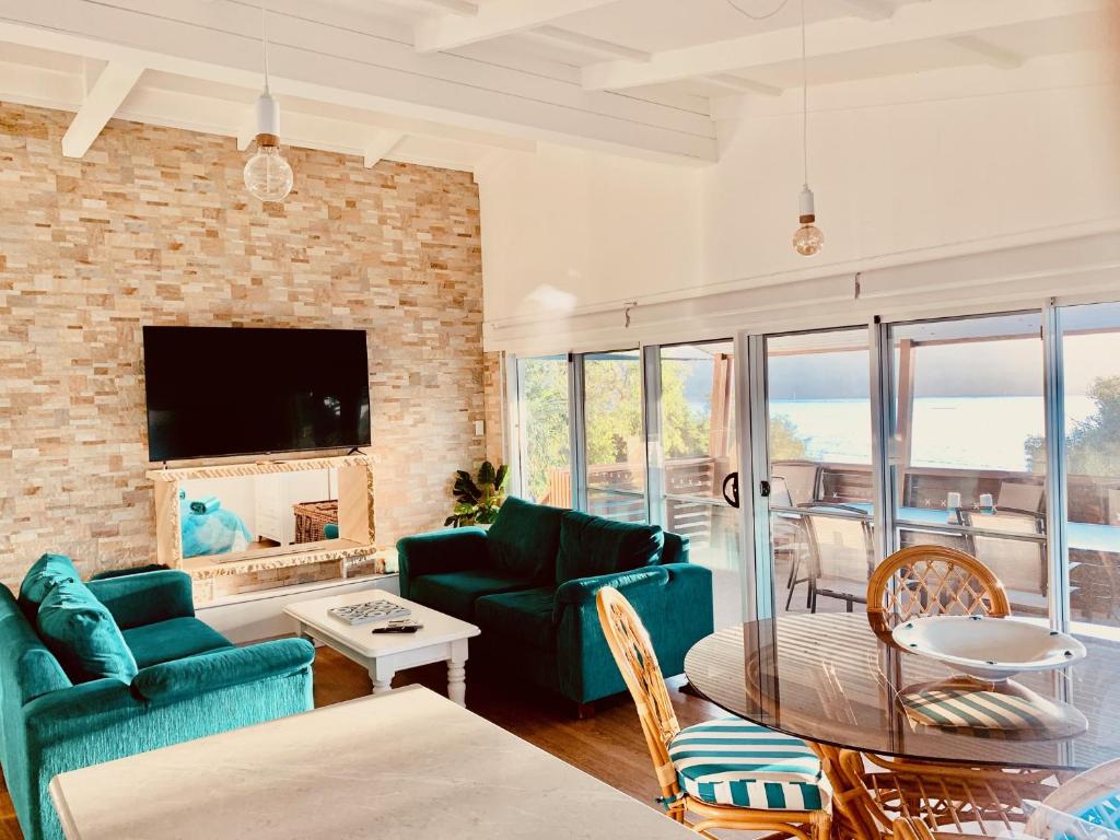 a living room with blue furniture and a brick wall at Blue River Apartments in Wooli