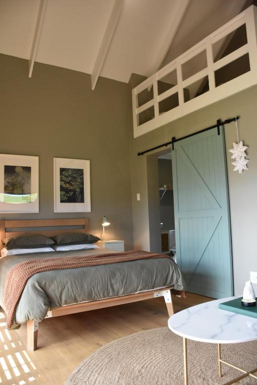 a bedroom with a bed with a blue door at Kileen Cottage in Nottingham Road