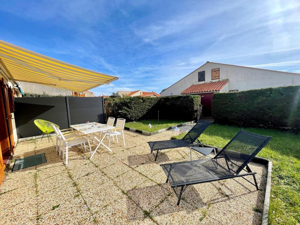eine Terrasse mit Stühlen und einem Tisch im Hof in der Unterkunft Maison Brem, 2 pièces, 4 personnes - FR-1-231-315 in Brem Sur Mer