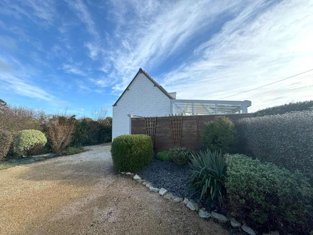 a small white house with a fence in front of it at Maison avec WIFI, véranda, à 320m de la mer et à 500m de la plage, à Trégastel - FR-1-368-408 in Trégastel