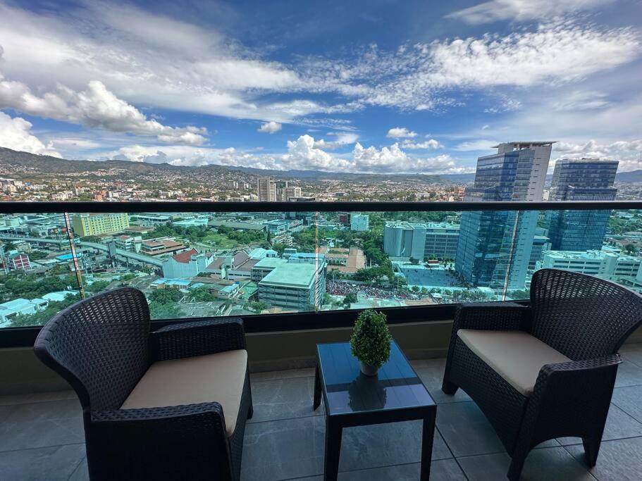 een balkon met 2 stoelen en een tafel en uitzicht bij Luxury 2BR Apartment in Astria 605 in Tegucigalpa