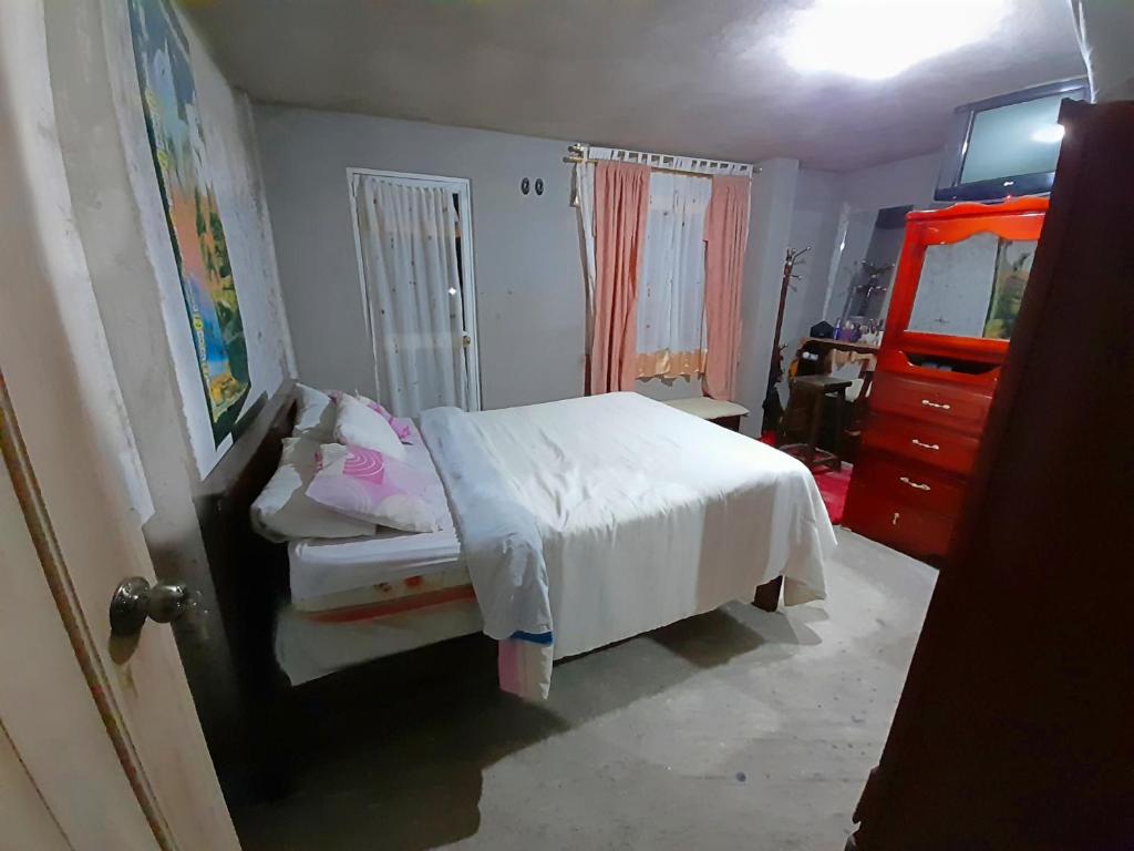 1 dormitorio con cama blanca y vestidor en ENCALADA, en Otavalo