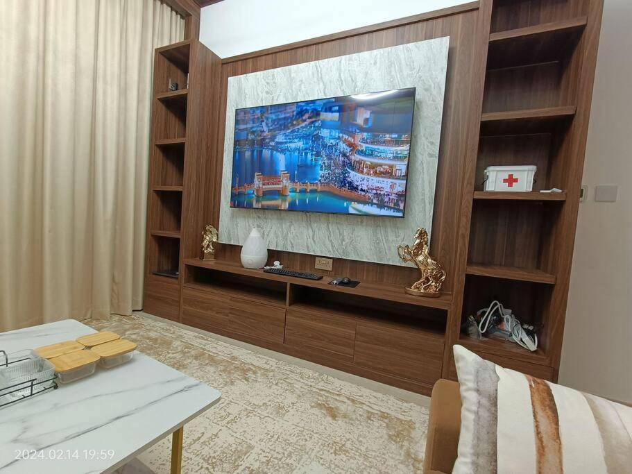 a living room with a television on a wall at una Town Square. Dubai in Dubai