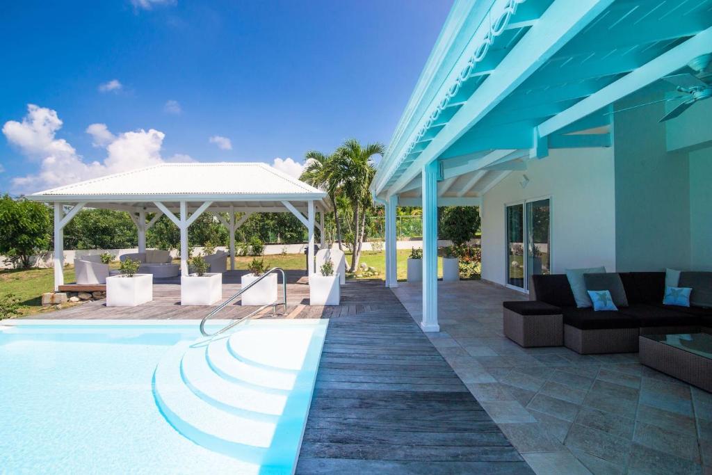een villa met een zwembad met stoelen en een paviljoen bij Luxury Vacation Villa 7 in Les Terres Basses