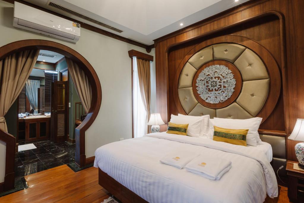 清邁的住宿－Lunar Mansion Hotel，卧室配有一张白色大床和木制床头板