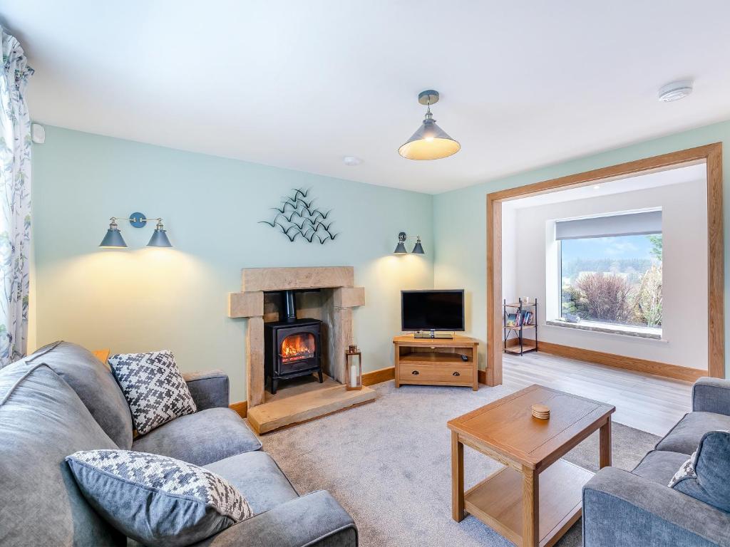 a living room with a couch and a fireplace at Home Farm Cottage in Sawley