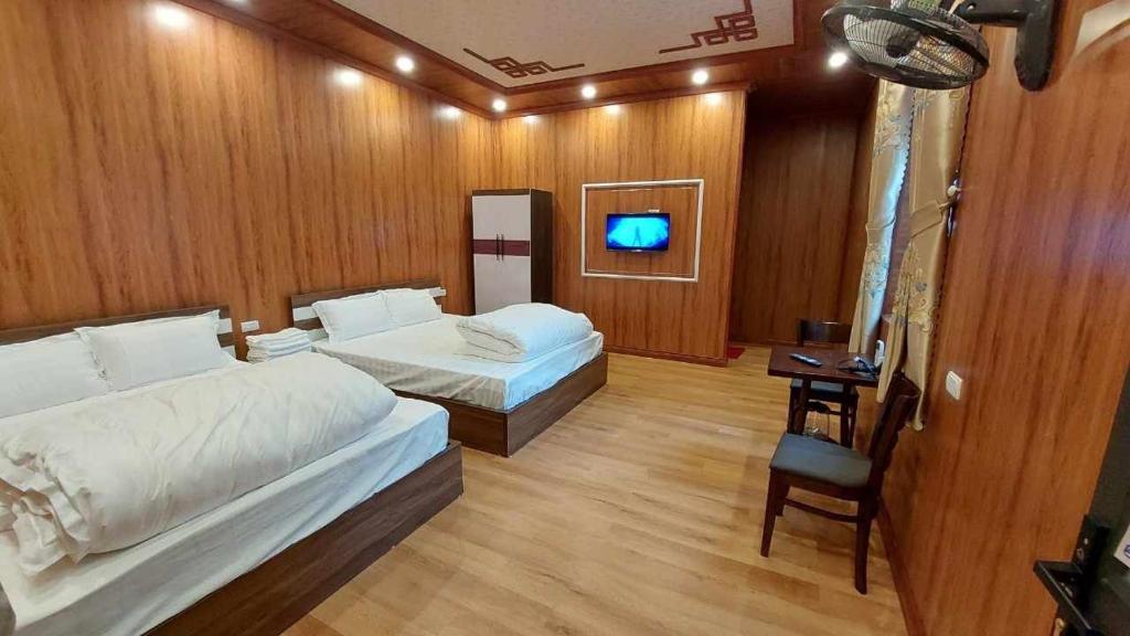 同文的住宿－NHÀ NGHỈ-HOMESTAY -KHÁCH SẠN ĐỒNG VĂN Hà Giang，一间酒店客房,设有两张床和电视