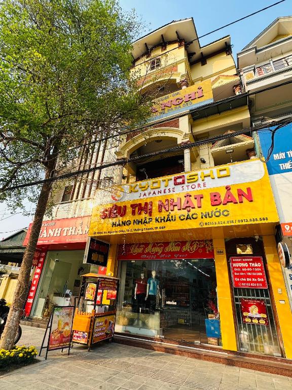 a store with a yellow sign in front of a building at Huong Thao Hostel & Tours in Dien Bien Phu