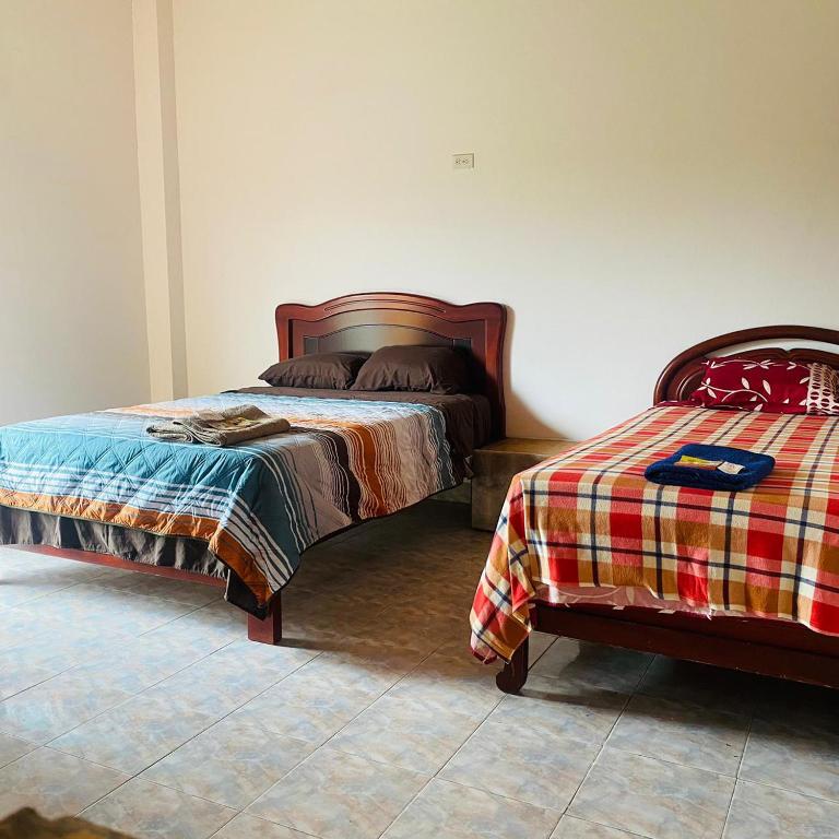 een slaapkamer met 2 bedden in een kamer bij Cabañas Barú in Tena