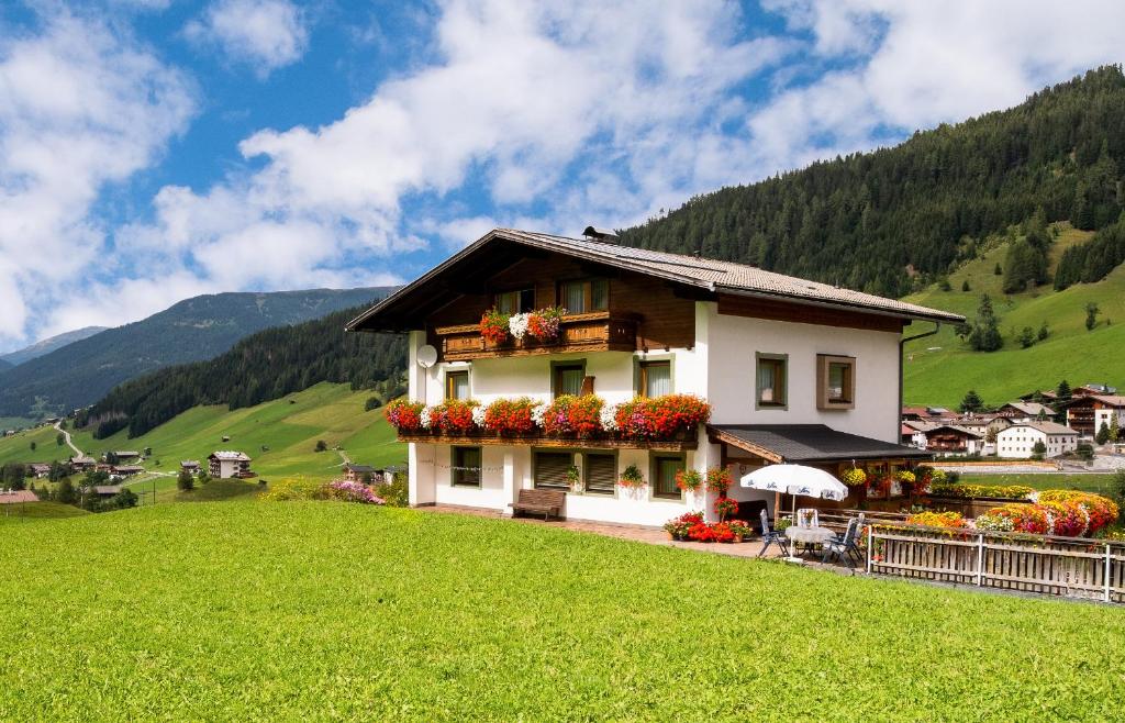 a house on a hill in a green field at Haus Annemarie Apartments Kartitsch - Hochpustertal in Kartitsch