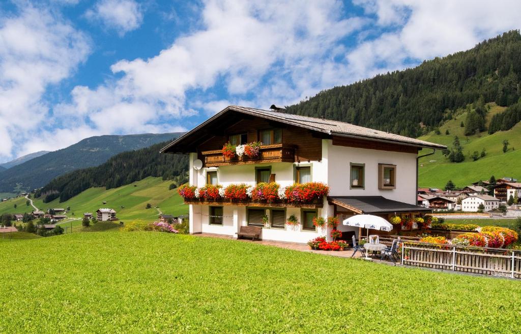 a house on a hill in a green field at Haus Annemarie Apartments Kartitsch - Hochpustertal in Kartitsch