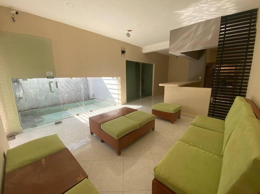 a living room with a couch and a table and a pool at Ko'ox 52 in Mérida