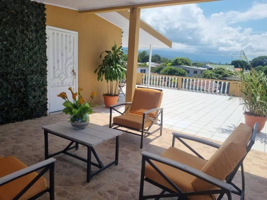 un patio con sedie, un tavolo e un balcone di Casa del Ángel #10 a La Ceiba
