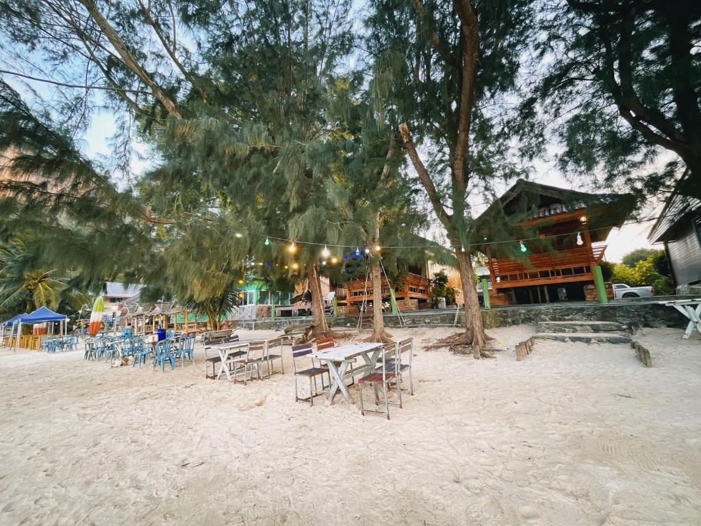 un grupo de mesas y sillas en la playa en Wangsarai Resort, en Don Sak
