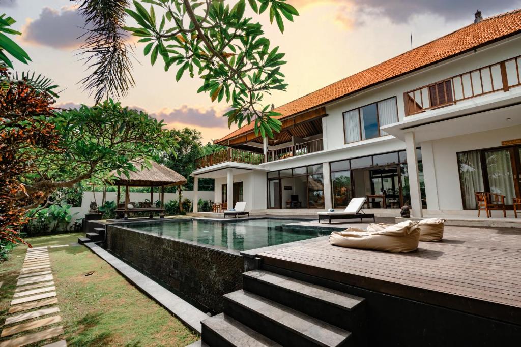 eine Villa mit Swimmingpool und ein Haus in der Unterkunft Casa Margarita Bali in Canggu
