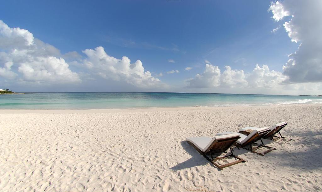 two chairs sitting on a beach with the ocean at Hotel Esencia in Xpu Ha