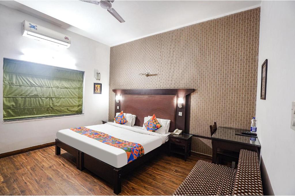 Habitación de hotel con cama y escritorio en FabHotel City Chalet Saket, en Nueva Delhi