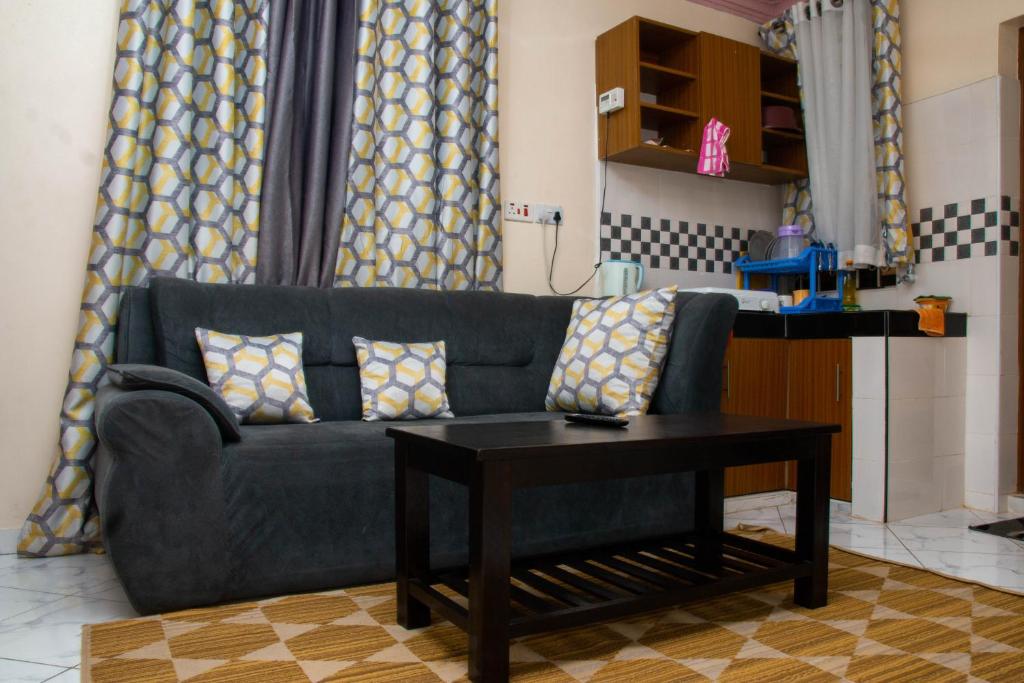 een woonkamer met een blauwe bank en een tafel bij Beach Box Dimash Apartments in Mombasa