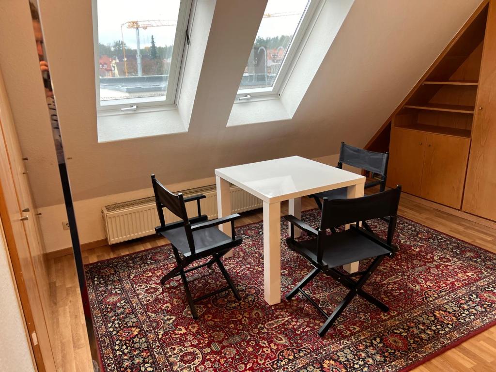 1 mesa y 2 sillas en una habitación con 2 ventanas en Wunderschöne Maisonette Wohnung in Wendelstein - Messenähe - Nürnberg, en Wendelstein