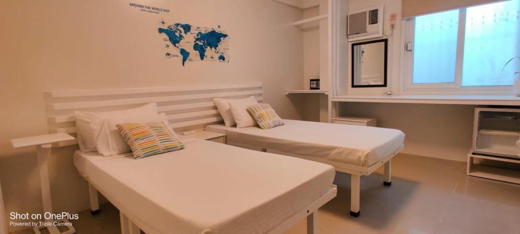 um quarto de hospital com duas camas e uma janela em Mecasa Hotel em Boracay