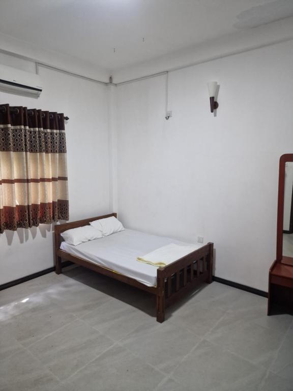 Posto letto in camera con parete bianca di Private AC BEDROOM in 2 Bed Villa - Coconut Beach a Midigama East