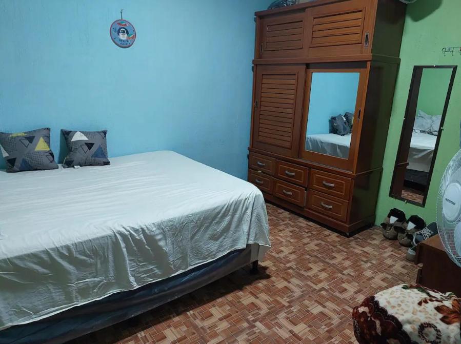 a bedroom with a bed and a dresser and a mirror at Pequeña habitacion Amatitlan in Amatitlán
