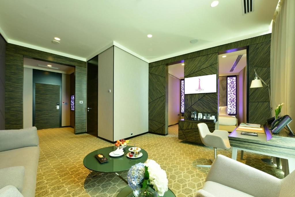 uma sala de estar com um sofá e uma mesa em The Torch Doha em Doha
