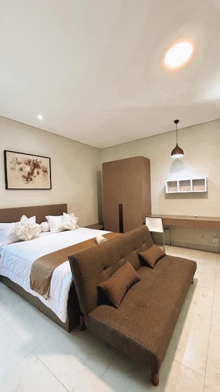 um quarto com uma cama grande e um sofá em Apartment Nawasena em Sanur
