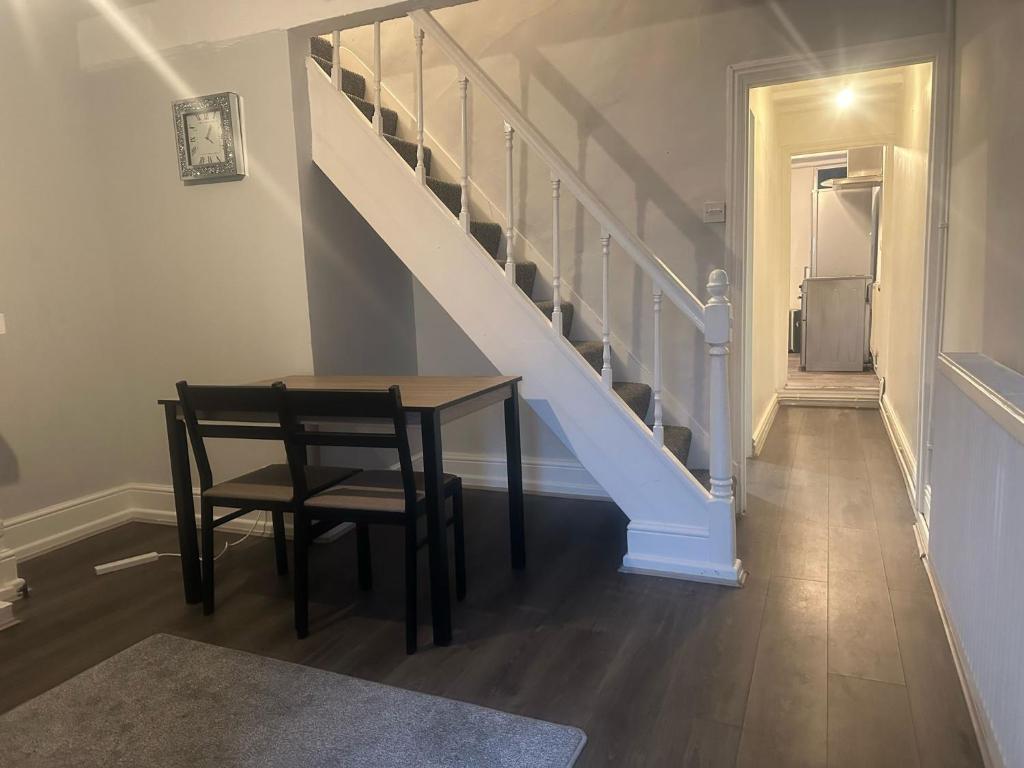a dining room with a table and a staircase at Prime Alexandra Place in Chatham