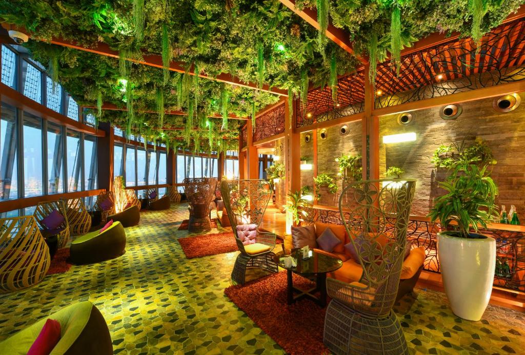 uma sala de estar com plantas no tecto em The Torch Doha em Doha