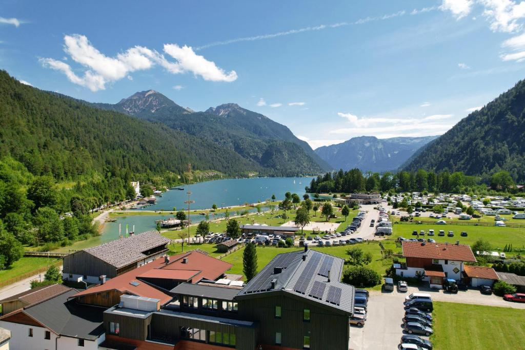 an aerial view of a resort with a lake and mountains at Karlingerhof in Achenkirch