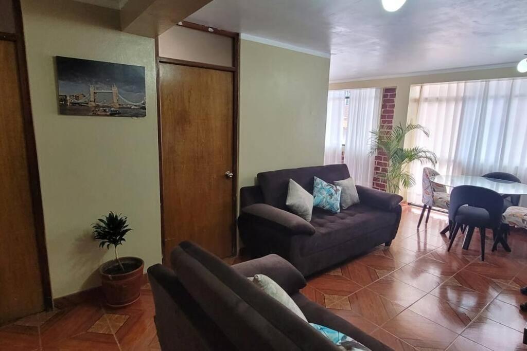 een woonkamer met een bank en een tafel bij Departamento a 2 cuadras de plaza in Ayacucho