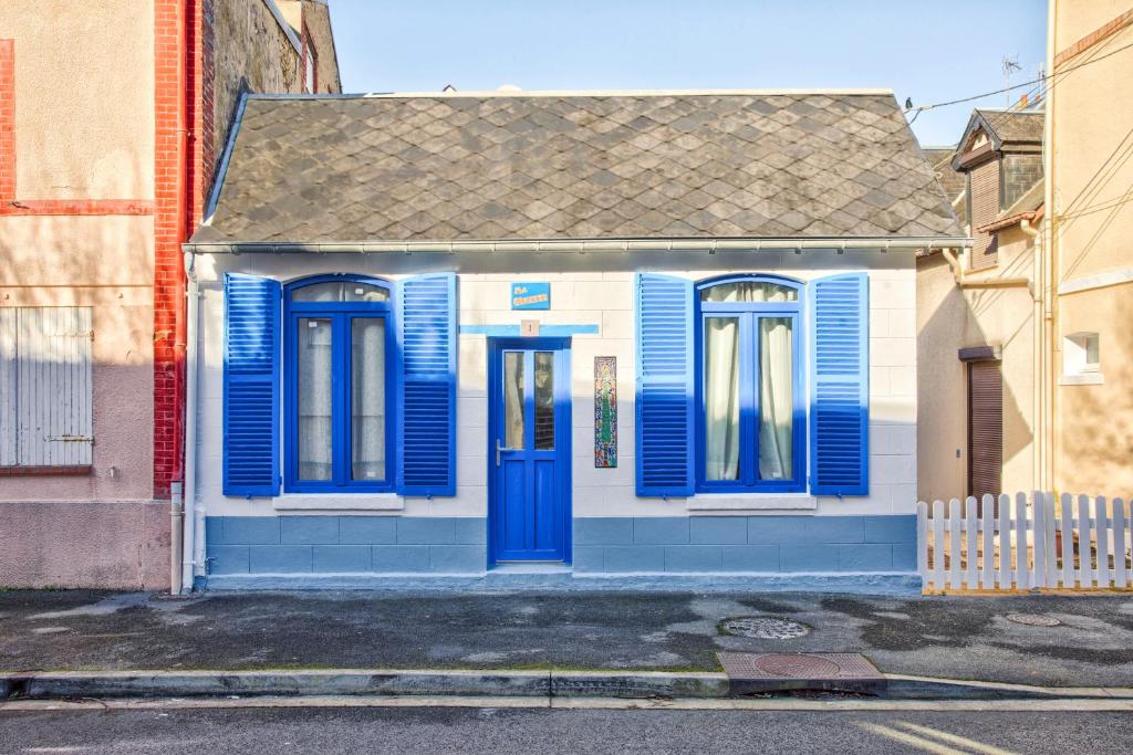 a blue and white house with blue doors on a street at La Maison de Pêcheur de Ginette in Cabourg