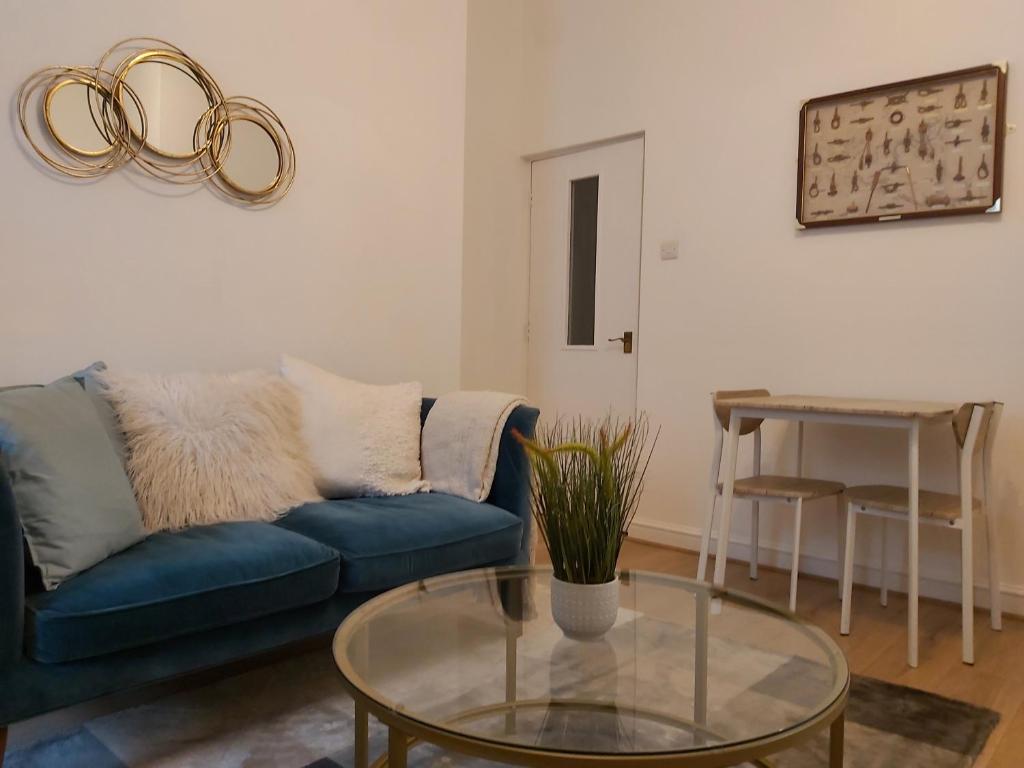 a living room with a blue couch and a glass table at Portsmouth Apartment *Newly refurbished *Central in Portsmouth