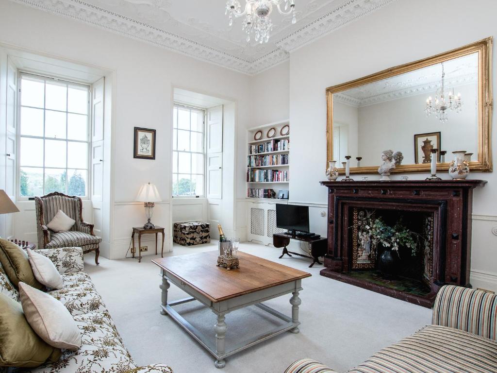 uma sala de estar com lareira e espelho em Royal Crescent Apartment em Bath