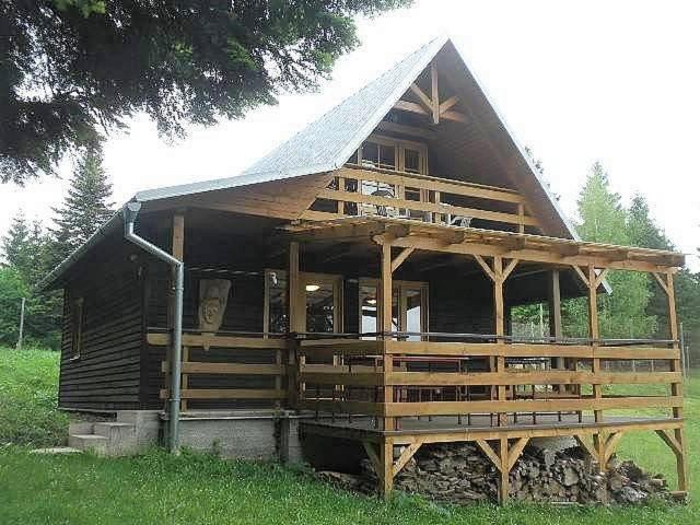 a large wooden house with a gambrel roof at Útulná chata na horách in Valašské Klobouky