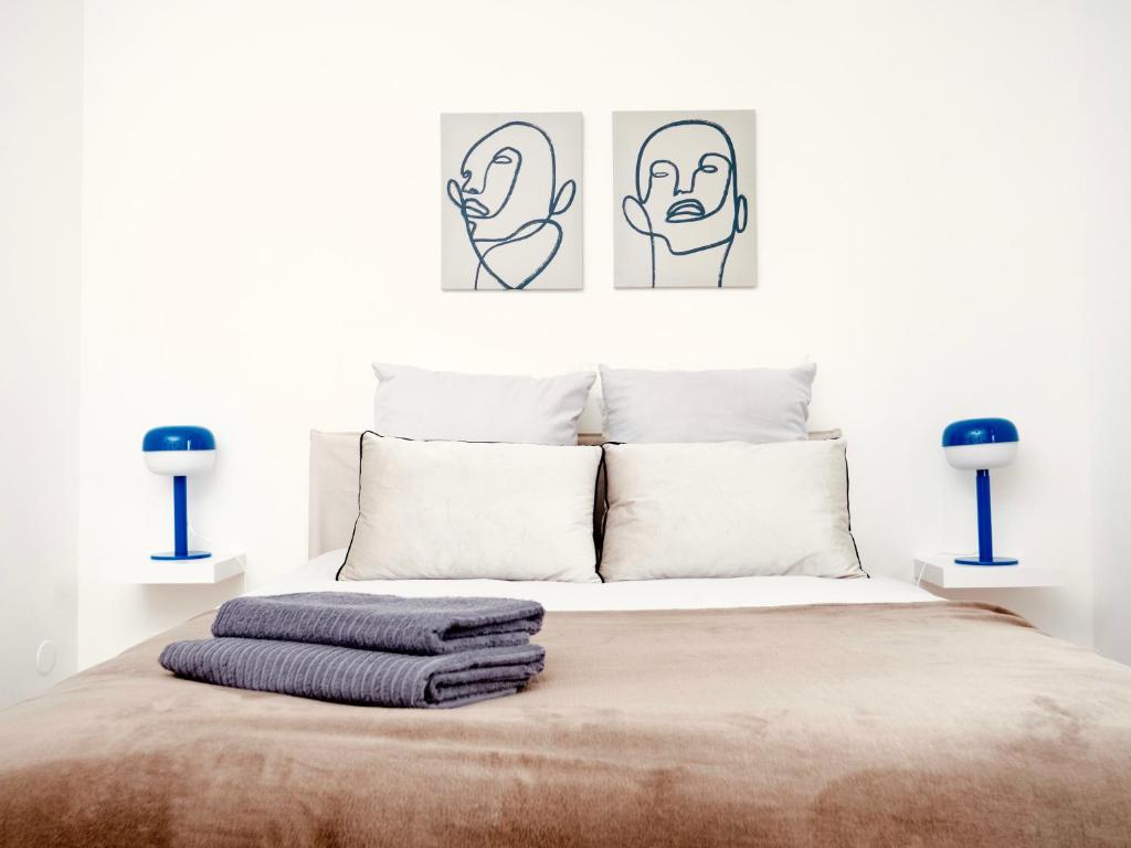 una camera con un letto con due immagini sul muro di Le 6 - Appartement douillet strasbourgeois avec terrasse a Strasburgo