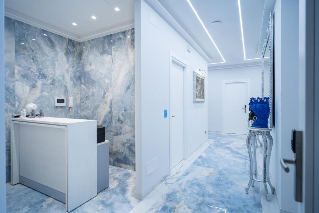 uma casa de banho com paredes em mármore azul e um corredor em Correnti Boutique Luxury Rooms em Sanremo